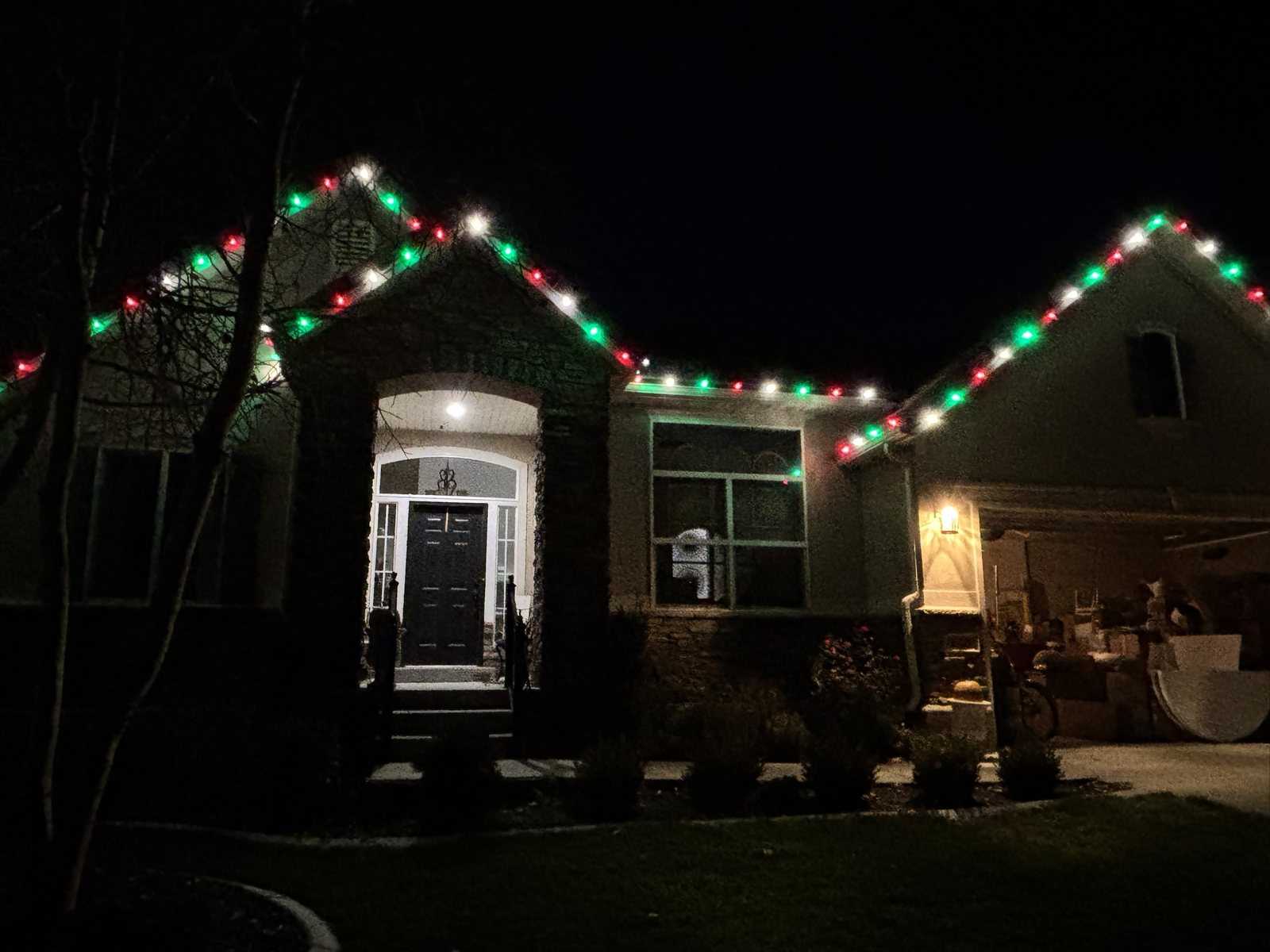 A home lit with red, green and white roofline lights
