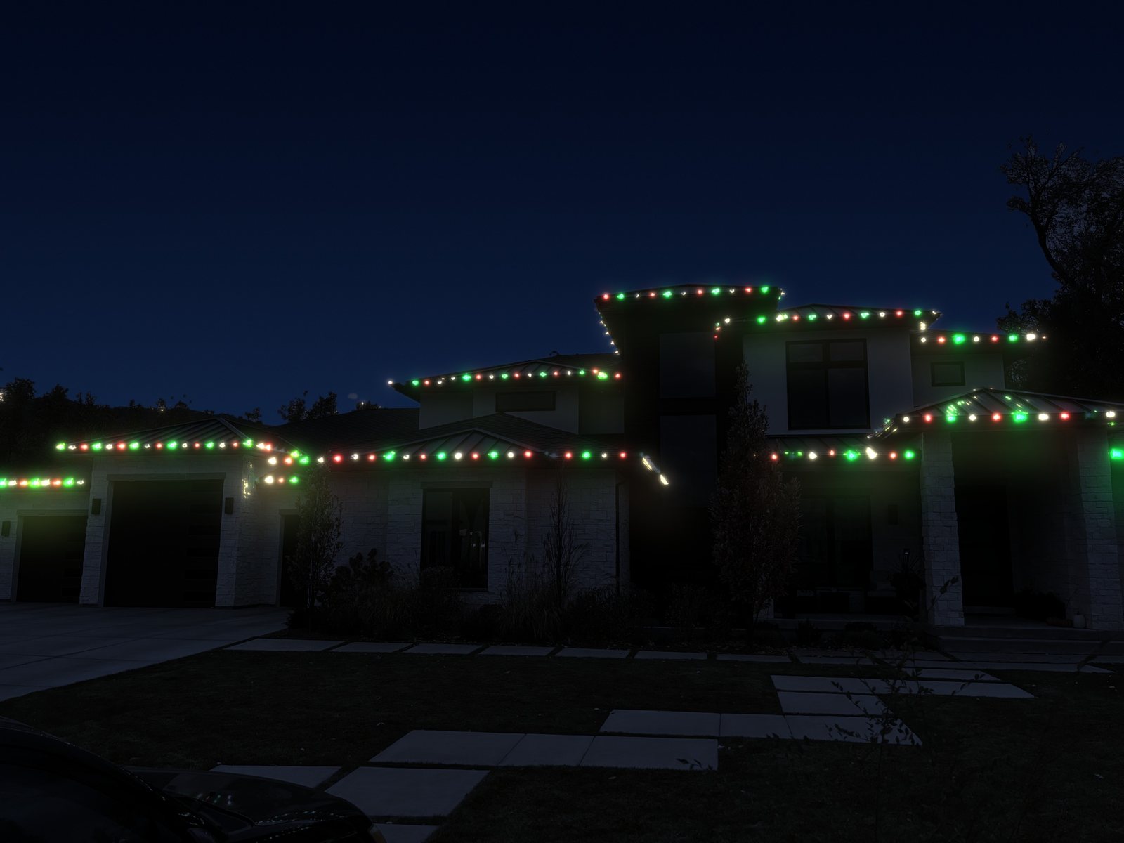 A two-story home with red, green and white roofline lights